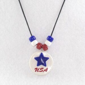 White clay disc with blue star, red USA vinyl letters, red, white, blue pony beads on a nylon cord.