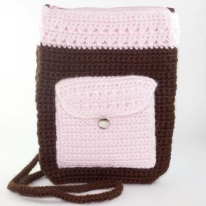 Brown and pink crochet body bag with front button pocket and zipper top.