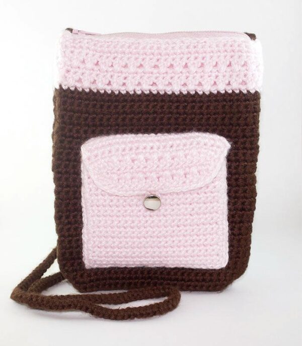 Brown and pink crochet body bag with front button pocket and zipper top.