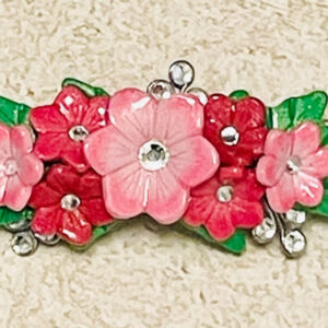 Pink clay flowers barrette with rhinestones and green leaves.