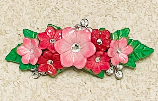 Pink clay flowers barrette with rhinestones and green leaves.